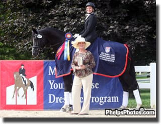 Cover - DressageDaily's Mary Phelps a Markel Equine Insurance Specialist, steps from behind the camera to present the trophy to Emily Wagner and Wake Up, 2011. (Photo Credit: Helen Murray)