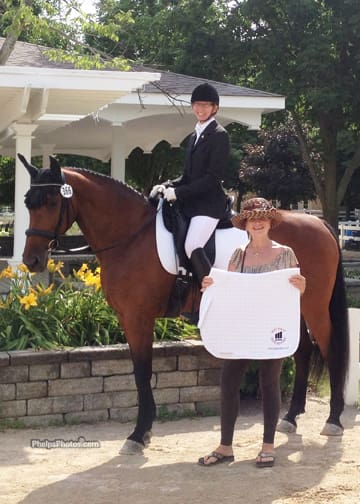 Cover - DressageDaily's Mary Phelps, a Markel Equine and Farm Insurance agent presents the Lamplight High Point Amateur Award, a Back On Track Therapeutic Saddle Pad to Donna Chiocca and Silke. 2012. (Photo: April Therrien for phelpsphotos.com)