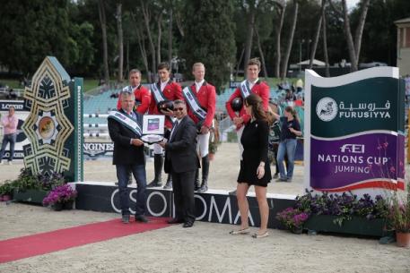  The Belgian team enjoyed their very first victory in Rome (ITA) today when winning the third leg of the Furusiyya FEI Nations Cup™ Jumping Europe Division 1 league.  Pictured on the podium are: (L to R) Ludo Philippaerts, Nicola Philippaerts, Niels Bruynseels and Constant van Paesschen.  Front (L to R) Belgian Chef d’Equipe Kurt Gravemeier, Dr Adil Nofal, Kingdom of Saudi Arabia’s Deputy Ambassador to Italy and Mrs Eleonora di Giuseppe, Coordinator CSIO Rome.  Photo: Stefano Secci/FEI.