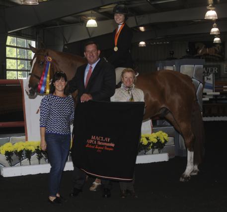 Left to Right: Brenda Tananbaum, Archie Cox and Carolyn Vincent present the top honorsto Charlotte Jacobs aboard Stallone VDL. Photo courtesy of Reflections Photography.