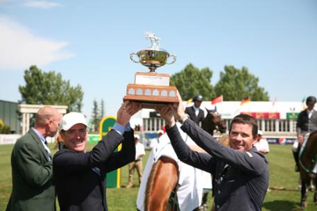 Tom Heathcott presents the Pan American Cup to grand prix winner Conor Swail. Photo © Spruce Meadows Media Services.
