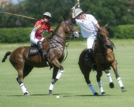 Audi's Grant Ganzi (1) pressures Juancito Bollini (2) as he hits the ball. Photo by Scott Fisher