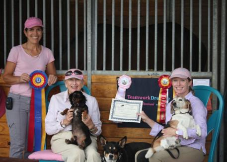 Jules Anderson, left, and her mother Libby Anderson, center, of Teamwork Dressage in Jupiter, Florida, show off their happy smiles after winning the Premier Sportsmanship Award at the Wellington Classic Holiday Challenge. The mother-daughter duo are joined by Theodora Dietrich, of North Port, Florida, and an assortment of Teamwork Dressage canines. Premier Equestrian, LLC, a leading supplier of dressage arenas, jumps, and stable accessories, sponsors the Premier Sportsmanship Award and the winner receives a 0 gift certificate from Premier. 