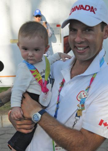 Jaimey Irwin holds Gavin, the couple’s six-month-old son, as he wears his mother’s Team Silver medal at the 2011 Pan American Games in Guadalajara, Mexico. (Photo: Dieter Busse)