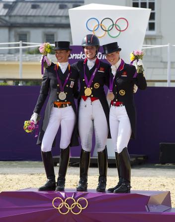 On the podium for the Dressage Freestyle which brought the equestrian events of the London 2012 Olympic Games to a close at Greenwich Park today - (L to R) - silver medallist Adelinde Cornelissen (NED), gold medallist Charlotte Dujardin (GBR), and bronze medallist Laura Bechtolsheimer (GBR).  Photo: FEI/Kit Houghton.