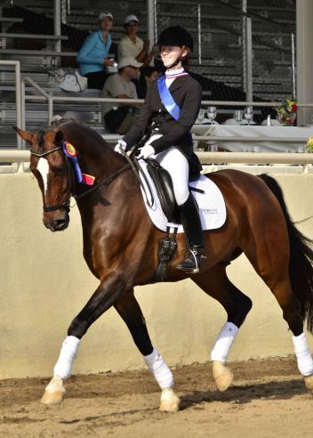 Gold Medalist Mickayla Frederick shows off her championship ribbons and HorseShow.com saddle pad during her victory lap at the 2013 USEF Dressage Seat Medal Finals. (Photo: yourhorses.ifp3.com/Kathleen Bryan)