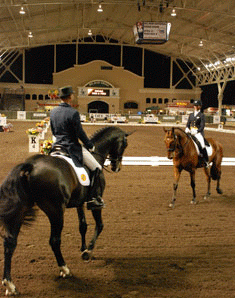 Steffen Peters and Ravel and Shannon Peters and Odyssey meet in the FEI arena as one finishes a Grand Prix, and the other begins. credit: Kelly Sanchez