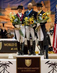 Tinne Vilhelmsson Silfven, Steffen Peters and Tina Konyot stand on the podium before a back drop of a Southern French scene during the awards presentation. (Photo Credit: Susan J. Stickle for Phelps Media Group)