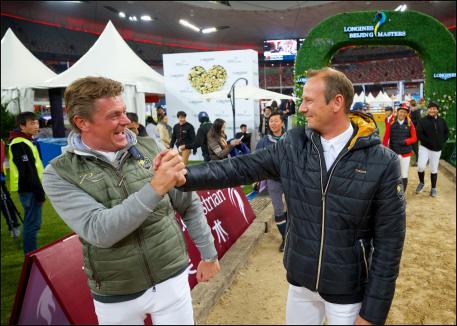 Jeroen Dubbeldam congratulates Marco Kutscher for his victory in the team jumping competition.