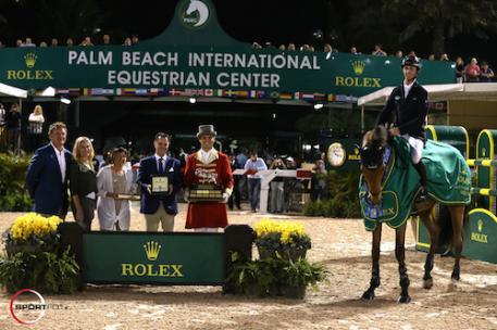Ben Maher and Sarena in their winning presentation with Equestrian Sport Productions CEO Mark Bellissimo; Wellington Equestrian Partners Principal  Katherine Bellissimo; Wellington Equestrian Partners' Marsha Dammerman;  Joël Aeschlimann, Head of Sponsorship, Rolex; and ringmaster Christian Craig.