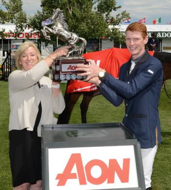Daniel Coyle lifts the winning trophy with Christine Lithgow, President & CEO, AON. 