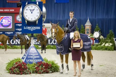 Harrie Smolders (NED) and Emerald (left), winners of the Longines FEI World Cup™ Jumping at the Washington International Horse Show, were presented with a Longines watch by Taylor Mace, National Event Manager for Longines. 