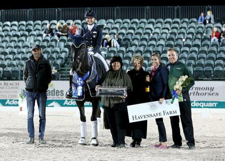 Katherine Bateson-Chandler and Alcazar in their presentation ceremony with groom Carl Chandler, Elizabeth Juliano of Havensafe Farm, judge Janet Foy (USA), Cora Causemann of AGDF, and Allyn Mann of Adequan®.