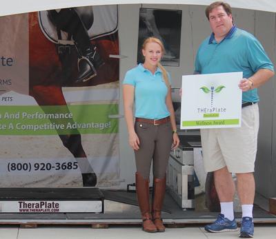 Chip Kreiling (right) of TheraPlate Revolution presents Mary Rollins (left) with the TheraPlate Award at TheraPlate’s booth at the Adequan Global Dressage Festival 