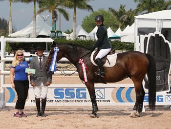 Daisy Farish, 14, won her first 0,000 High Junior Jumper Classic during week 11 of the Winter Equestrian Festival.  For wearing SSG ‘Digital’ riding gloves on her way to victory, Farish was presented with a ,000 bonus from Jennifer Ward, accompanied by Gustavo Murcia, in the SSG Gloves “Go Clean for the Green” promotion. Photo by Sportfot