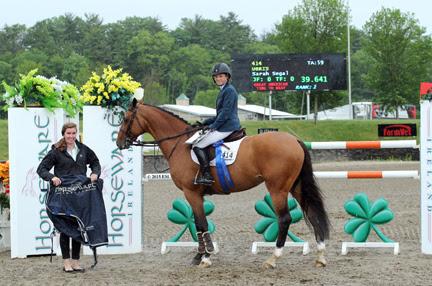 Sarah Segal and Chartwell's Ubris are presented with a Horseware Ireland cooler and the blue ribbon after winning the $75,000 Horseware Ireland Grand Prix at HITS-on-the-Hudson II (Photo: ESI Photography)