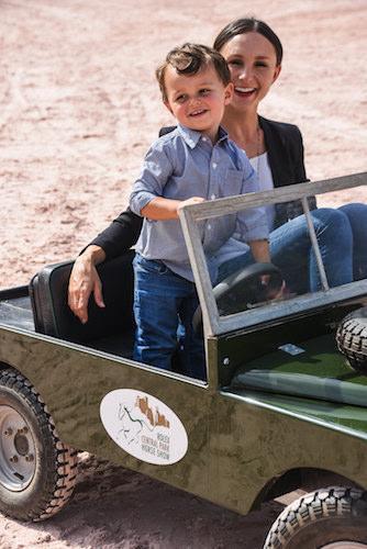 Georgina Bloomberg and her son Jasper  in a mini Land Rover vehicle.