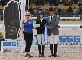 Daisy Farish, 14, won her first 0,000 High Junior Jumper Classic during week 11 of the Winter Equestrian Festival.  For wearing SSG ‘Digital’ riding gloves on her way to victory, Farish was presented with a ,000 bonus from Jennifer Ward, accompanied by Gustavo Murcia, in the SSG Gloves “Go Clean for the Green” promotion. Photo by Sportfot