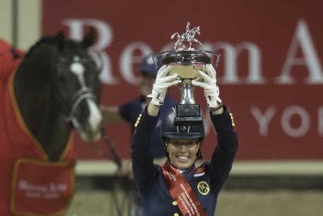 Great Britain’s Charlotte Dujardin holds the new Reem Acra trophy aloft after making it a back-to-back double of victories with the amazing Valegro at the Reem Acra FEI World Cup™ Dressage 2015 Final (FEI/Dirk Caremans)