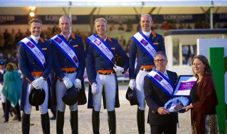  The Dutch team celebrate victory in the third leg of the FEI Nations Cup™ Dressage 2015 pilot series in Rotterdam, The Netherlands (L to R): Edward Gal, Diederik van Silfhout, Patrick van der Meer and Hans Peter Minderhoud. Dutch Chef d’Equipe, Wim Ernes, accepts the trophy from Show President, Belle de Bruin. (FEI/Arnd Bronkhorst)