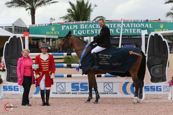 Eric Lamaze, mounted on Rosana du Park, is presented with a $3,000 bonus from Jennifer Ward on behalf of SSG Gloves for wearing SSG ‘Digitals’ on his way to victory in the $25,000 WEF Challenge Cup Round I at the 2015 Winter Equestrian Festival in Wellington, FL. Photo by Sportfot