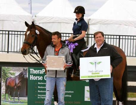 Crystal Kroetch and her coach Albrecht Heidemann smile at the Hanoverian Lymrix, who is presented with the TheraPlate Award by Chip Kreiling of TheraPlate Revolution 