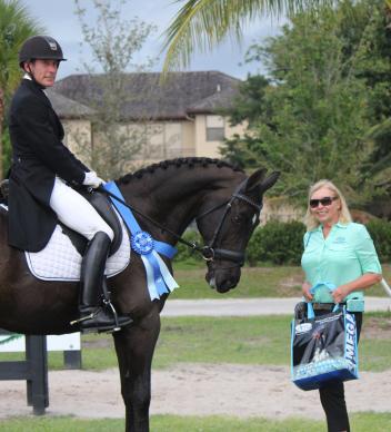 Ryan Yapp and Magic Moments (left) receive the Omega Alpha Healthy Horse Award from Patti Hanco (right) of Omega Alpha Pharmaceuticals Inc